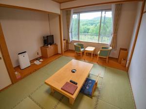 a living room with a table and a large window at Japanese Auberge Plaza Ryokufu Natural Hot Spring - Vacation STAY 03218v in Shimo-orube