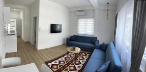 a living room with a blue couch and a table at Apartmani Art in Jajce