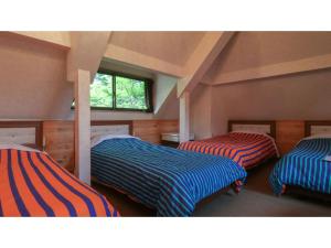 um quarto com 3 camas num sótão em Nikko Park Lodge - Vacation STAY 15306v em Nikko