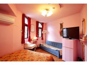 1 dormitorio con 1 cama y 1 sofá azul en Nikko Park Lodge - Vacation STAY 15295v, en Nikko