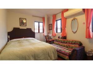 1 dormitorio con 1 cama, 1 silla y ventanas en Nikko Park Lodge - Vacation STAY 15295v, en Nikko