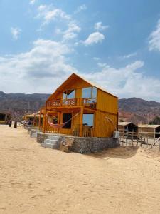 um edifício de madeira no meio do deserto em Full Moon Camp Sinai em Nuweiba