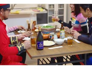 Un groupe de personnes assises autour d'une table avec de la bière dans l'établissement Sunset Village - Vacation STAY 15292v, à Onomichi
