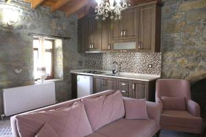 a living room with a couch and a kitchen at KALYOPİ TAŞ BUTİK OTEL in Gokceada Town