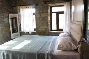 a bedroom with a bed in a room with a window at KALYOPİ TAŞ BUTİK OTEL in Gokceada Town