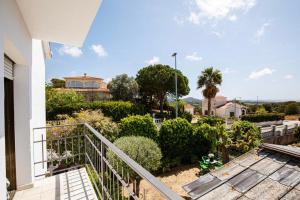 un balcone di una casa con cespugli e alberi di Maravillosa casa con piscina grande y bosque a Tordera