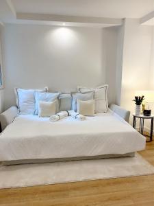 ein Schlafzimmer mit einem großen weißen Bett mit blauen Kissen in der Unterkunft Charming parisian apartment in Paris