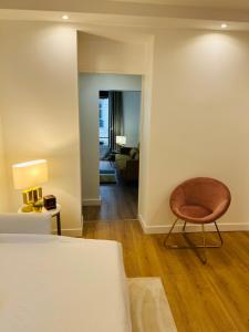 パリにあるCharming parisian apartmentのベッド1台、椅子、リビングルームが備わります。