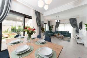 Villa 10 Palmeraie Golf Agadir في أغادير: غرفة طعام وغرفة معيشة مع طاولة خشبية