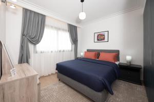 een slaapkamer met een blauw bed en een raam bij Villa 10 Palmeraie Golf Agadir in Agadir