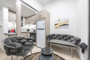 sala de estar con 2 sofás y cocina en Ano Patisia Station Studio en Atenas