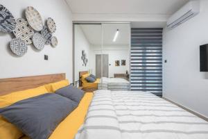 1 dormitorio con 1 cama grande y espejo en Ano Patisia Station Studio en Atenas