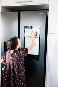 a woman looking at a picture on the side of a refrigerator at Suyapto House in Hahndorf