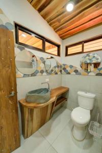 a bathroom with a toilet and a sink at Sámara Tarantela Houses, Casa Bambú in Sámara