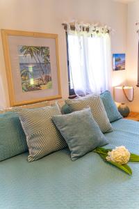 a blue bed with pillows and a flower on it at Ocean View Black Sand Beach House @ Kehena beach HI in Pahoa