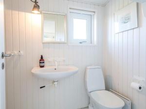 Un baño blanco con inodoro y lavabo. en 4 person holiday home in Fanø-By Traum, en Fanø 32 fotos más