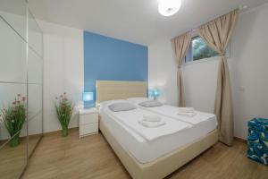 a white bedroom with a large bed and a window at Serviced Family Suite by the sea, Mezaninе lеvеl in Bol