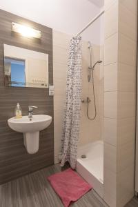 a bathroom with a sink and a shower at Apartamenty Kopernika in Toruń