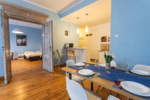 a dining room and living room with a table and chairs at Apartamenty Kopernika in Toruń