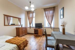 a living room with a dining room table and a television at Apartamenty Kopernika in Toruń