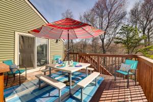 eine Terrasse mit Tisch und Stühlen und einem Sonnenschirm in der Unterkunft Dock and Fire Pit Lakefront Poconos Retreat! in Long Pond