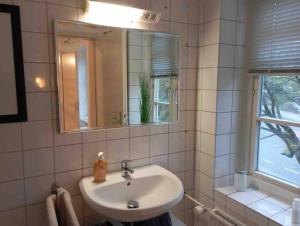 a bathroom with a sink and a mirror and a window at Loft in Flensburgs Zentrum in Flensburg