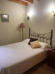 a bedroom with a white bed with two pillows on it at La Canal in Ubiarco