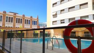 widok na basen z czerwonym przedmiotem w obiekcie On the beach! Frente al Paseo Marítimo, Parking y Piscina w Maladze