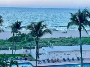 ein Resort mit einem Pool, Palmen und dem Meer in der Unterkunft Chic Ocean Front Studio! in Miami Beach