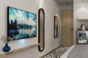 a bedroom with a large flat screen tv on a wall at Erzurumlu Hotel in Kilyos