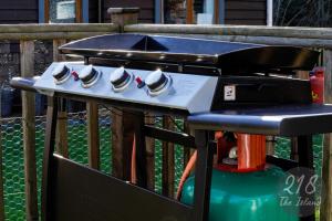 a barbecue grill with four teacups on it at The Cabin, Glan Gwna in Caernarfon
