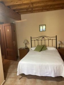 a bedroom with a bed with white sheets and green pillows at La Canal in Ubiarco