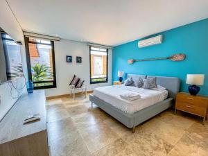 een slaapkamer met een bed en een blauwe muur bij Casa Quinta de Lujo Villeta MyS in Villeta