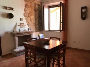 une salle à manger avec une table et une cheminée dans l'établissement CASA VACANZE "SU PORTALE", à Gonnesa