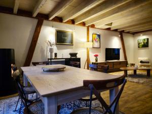 een woonkamer met een grote houten tafel en stoelen bij La Maison Rouge Au coeur de la ville. in Riquewihr