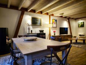 a living room with a large wooden table and chairs at La Maison Rouge Au coeur de la ville. in Riquewihr