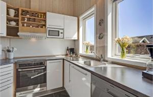 a kitchen with white cabinets and a sink and a window at Cozy Home In Haderslev With Sauna in Haderslev