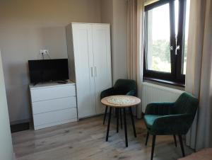 Pokój ze stołem, 2 krzesłami i telewizorem w obiekcie Dom z widokiem w Smołdzinie