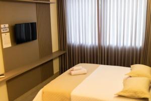 a bedroom with a bed with two towels on it at ESCARPAS FLATS in Capitólio