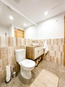 a bathroom with a toilet and a sink at El Olivo by ALÔGA in Corcubión