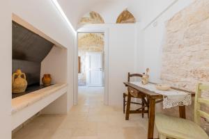 a kitchen with a table and a stone wall at Le Casette in Gravina Luxury in Villa Castelli