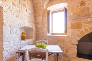 a dining room with a table and a window at Le Casette in Gravina Luxury in Villa Castelli
