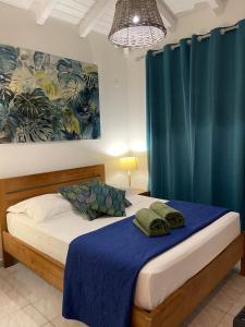 - une chambre avec un lit doté d'un rideau bleu dans l'établissement Côté Plage, à Saint-François