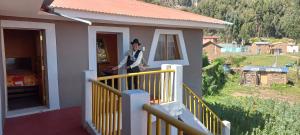 Musiña Lodge في Ocosuyo: امرأة تقف على شرفة المنزل