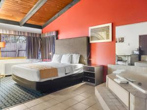 Habitación de hotel con cama y bañera en Americas Best Value Inn Hinckley, en Hinckley