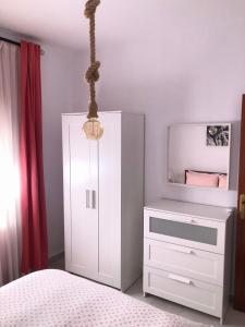 a bedroom with a white cabinet and a mirror at Apartamento La Habana Vieja in Jerez de la Frontera