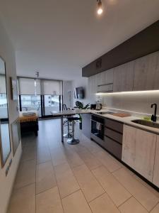 a kitchen with a counter and a table in it at Apartamentos Bauerle Curitiba in Temuco