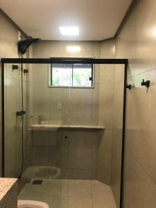 a shower with a glass door in a bathroom at ESCARPAS FLATS in Capitólio