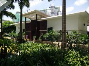 une maison avec des palmiers et des plantes devant elle dans l'établissement Indah Alam Condo, à Shah Alam
