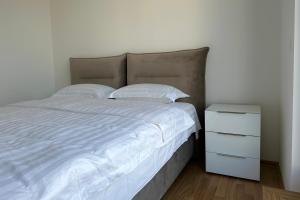 a bedroom with a white bed and a night stand at Penthouse in Vienna - near metro in Vienna